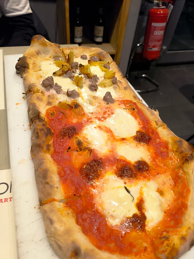 Pizza alla pala lunga metà rossa con salsiccia e metà bianca con patate