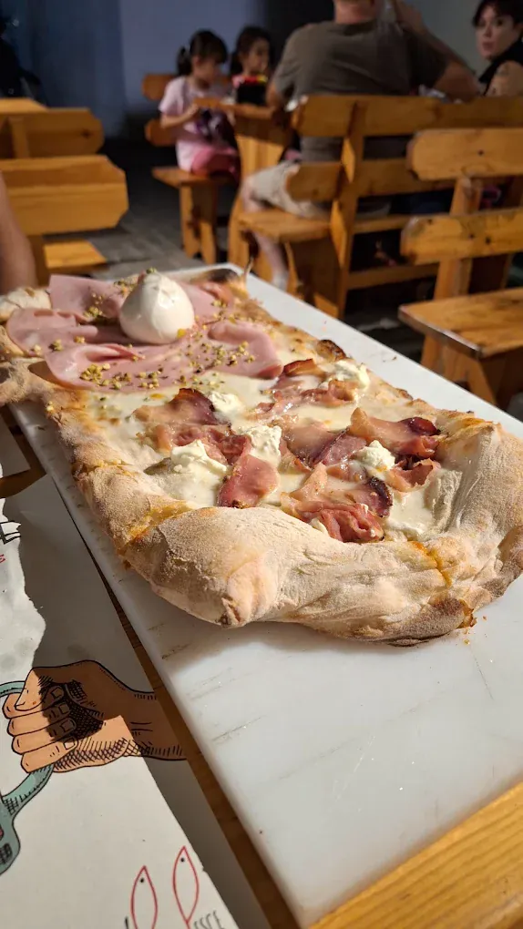 Pizza alla pala con mortadella e burrata servita sui tavoloni della terrazza