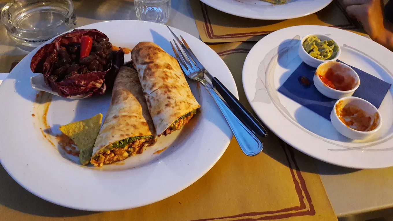 Cena in terrazza al tramonto con wrap e salse